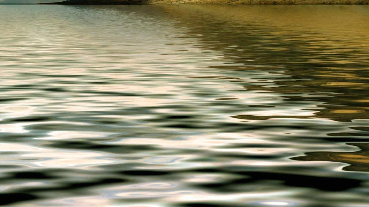 Close up of ripples on a river during sunset.